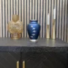 A cremation urn featuring birds in flight, sitting on a cabinet for sale in a shop in Perth