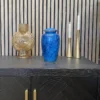 a blue cremation urn sitting on a cabinet for sale for human ashes